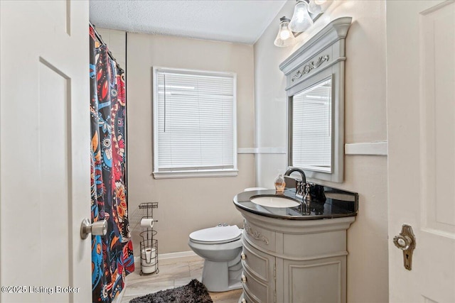 bathroom with toilet, a textured ceiling, and vanity