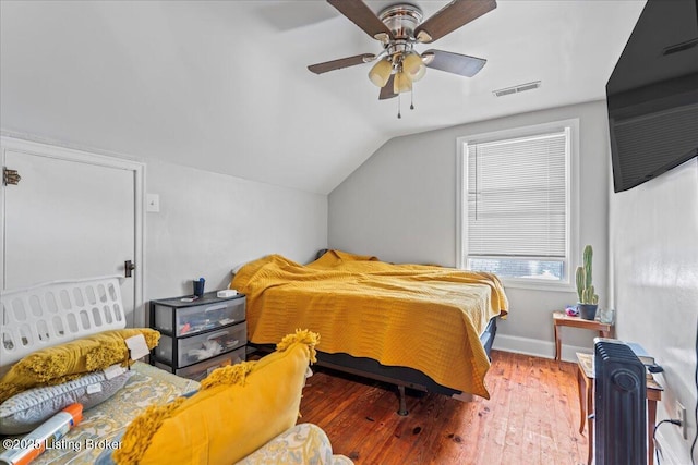 bedroom with ceiling fan, dark wood-type flooring, and vaulted ceiling