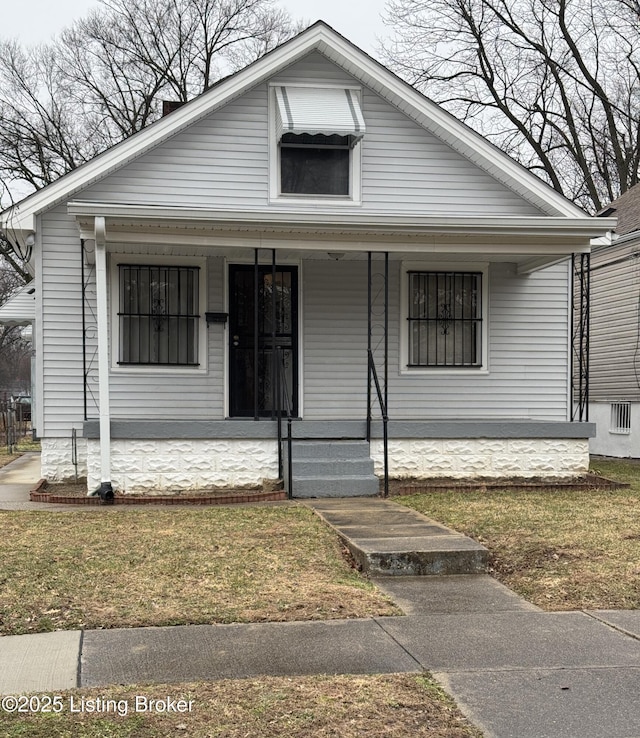 bungalow with covered porch and a front yard