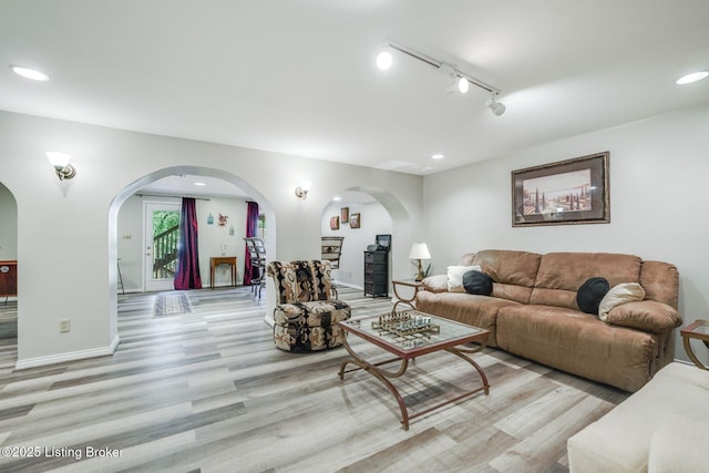 living room with rail lighting and light hardwood / wood-style flooring