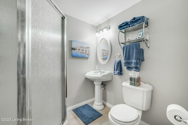 bathroom with a shower with door, tile patterned floors, and toilet