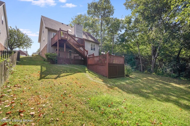 back of house with a deck and a lawn