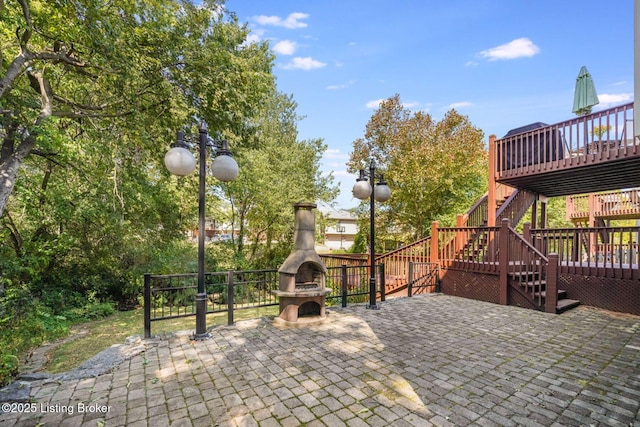 view of patio with an outdoor stone fireplace and a deck