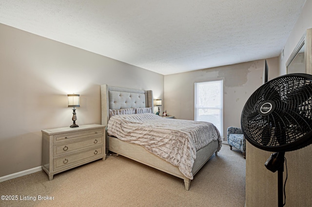 bedroom with light colored carpet and a textured ceiling