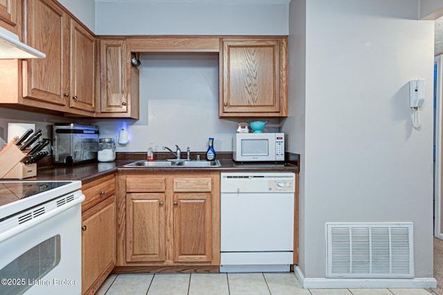 kitchen featuring light tile patterned flooring, white appliances, and sink