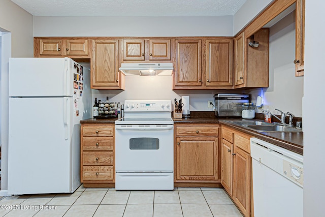 kitchen with sink, light tile patterned floors, a textured ceiling, and white appliances