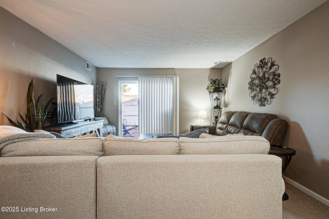 carpeted living room featuring a textured ceiling