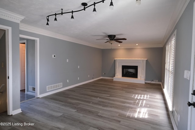 unfurnished living room featuring crown molding, visible vents, a fireplace with raised hearth, and baseboards