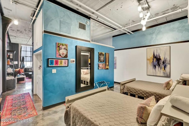 bedroom featuring a towering ceiling and concrete flooring