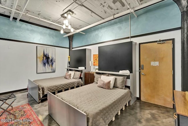 bedroom featuring concrete floors and a high ceiling