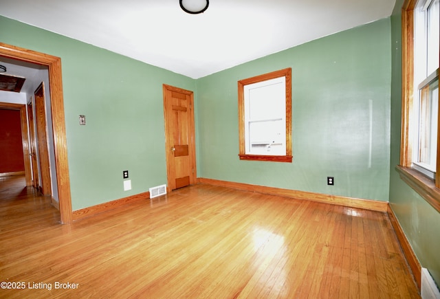 unfurnished bedroom featuring multiple windows and light wood-type flooring