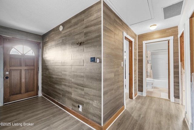 foyer featuring hardwood / wood-style flooring and wood walls