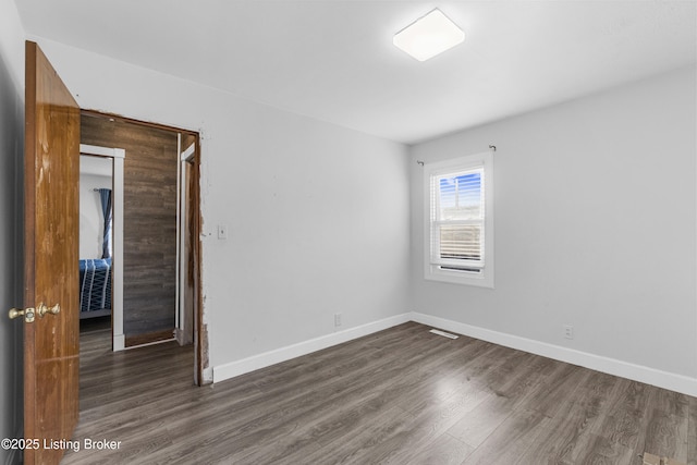 spare room featuring dark wood-type flooring