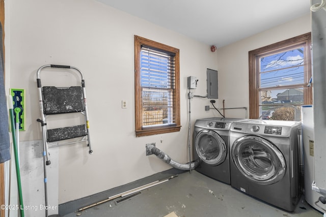 clothes washing area with washer and clothes dryer, electric panel, and water heater