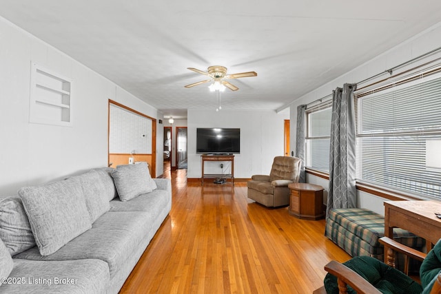 living room with hardwood / wood-style floors, built in features, and ceiling fan