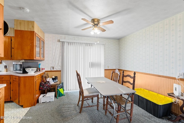 dining area featuring ceiling fan and light colored carpet