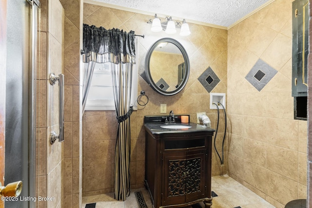 bathroom featuring vanity, a textured ceiling, and tile walls