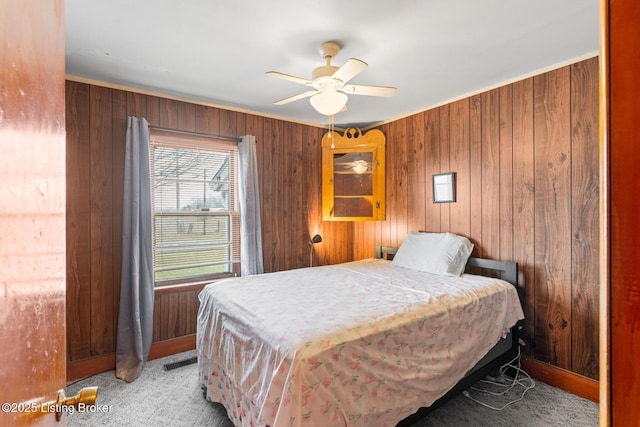 bedroom with carpet floors, ceiling fan, and wood walls