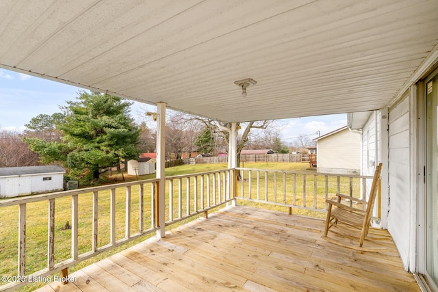 wooden deck featuring a storage shed and a yard