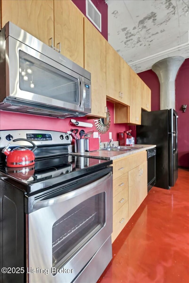 kitchen with concrete flooring and black appliances