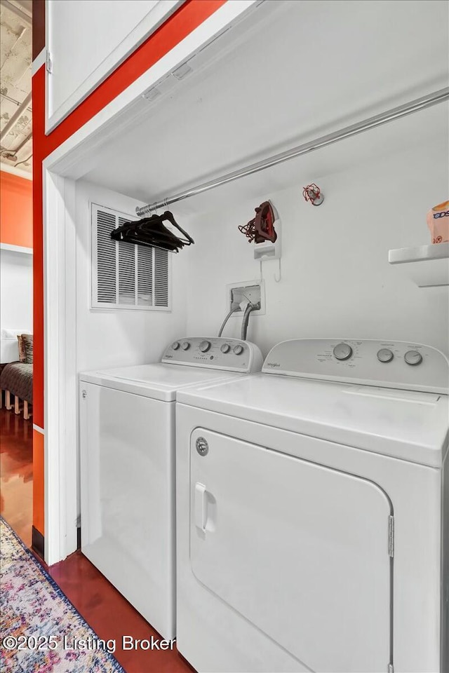 laundry area with washing machine and clothes dryer and dark hardwood / wood-style floors