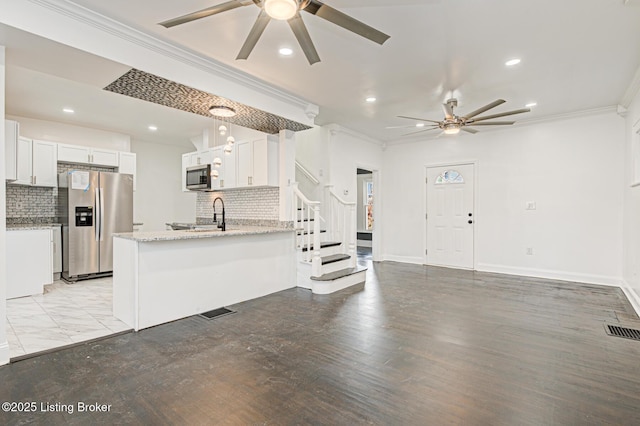 kitchen featuring decorative light fixtures, ornamental molding, stainless steel appliances, and white cabinets