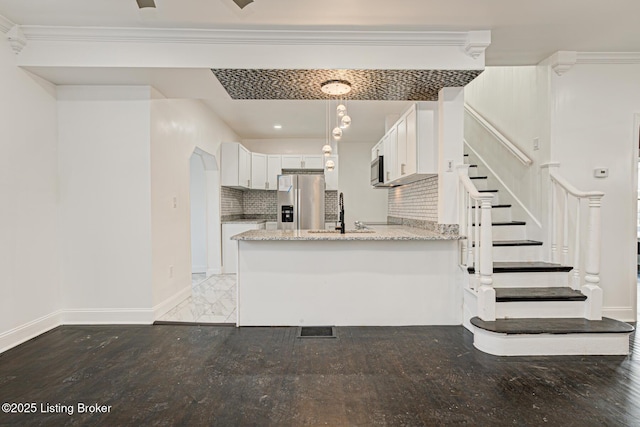 kitchen featuring white cabinetry, sink, hanging light fixtures, light stone counters, and stainless steel appliances