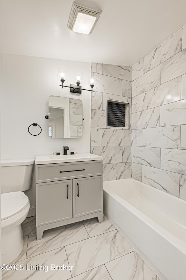 full bathroom featuring vanity, tiled shower / bath combo, and toilet