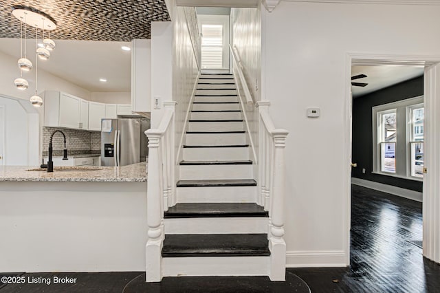 stairs featuring hardwood / wood-style flooring and sink