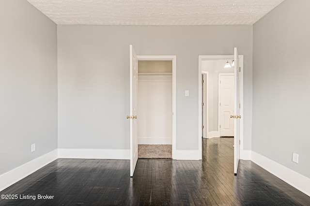 unfurnished bedroom with dark hardwood / wood-style flooring, a closet, and a textured ceiling