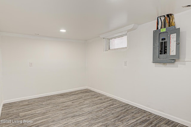 basement with hardwood / wood-style flooring and electric panel