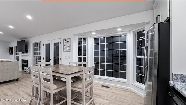 dining space with french doors and light wood-type flooring