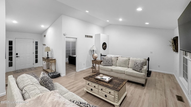 living room featuring vaulted ceiling and light hardwood / wood-style flooring