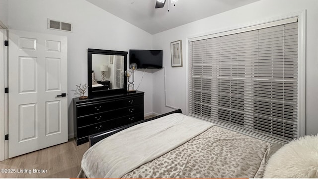 bedroom featuring lofted ceiling, light hardwood / wood-style flooring, and ceiling fan