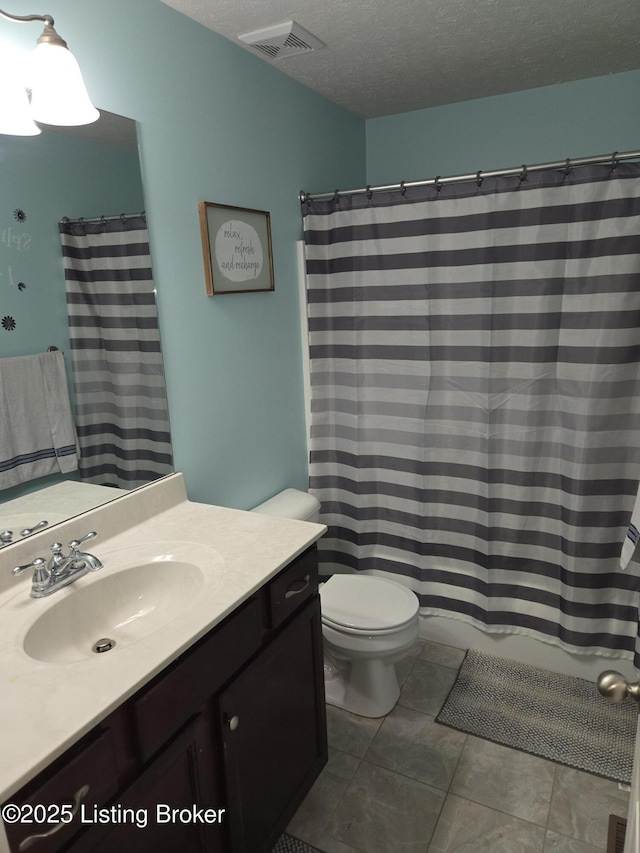 bathroom featuring vanity, tile patterned floors, a textured ceiling, and toilet