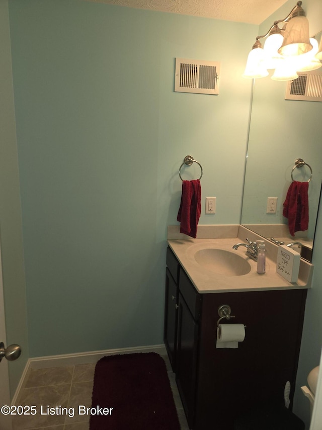 bathroom with vanity, tile patterned flooring, and a textured ceiling