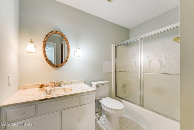 bathroom featuring tile patterned flooring, shower / bath combination with glass door, vanity, and toilet