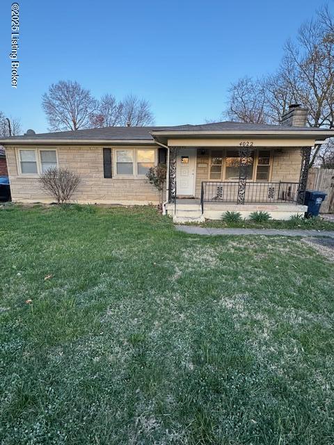 single story home featuring a porch and a front lawn