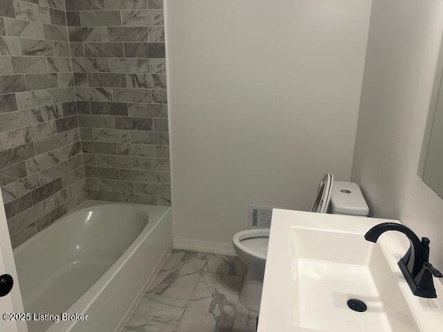 full bathroom with sink, tiled shower / bath combo, and toilet