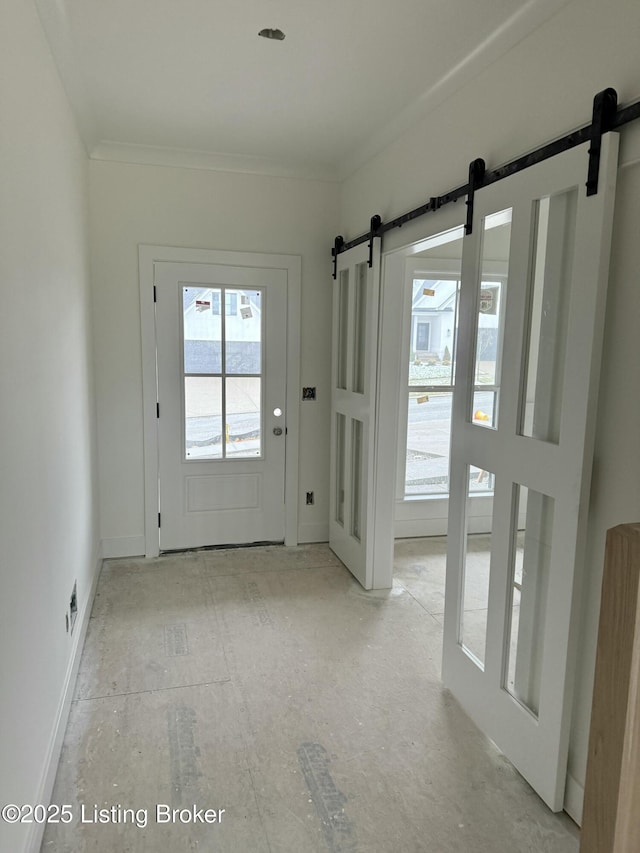 doorway to outside featuring crown molding and a barn door