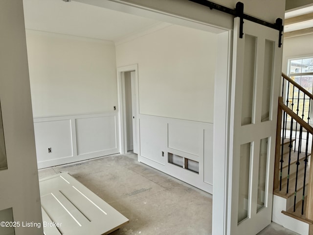 hall featuring ornamental molding and a barn door