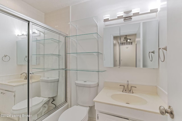 full bathroom with vanity, shower / bath combination with glass door, and toilet