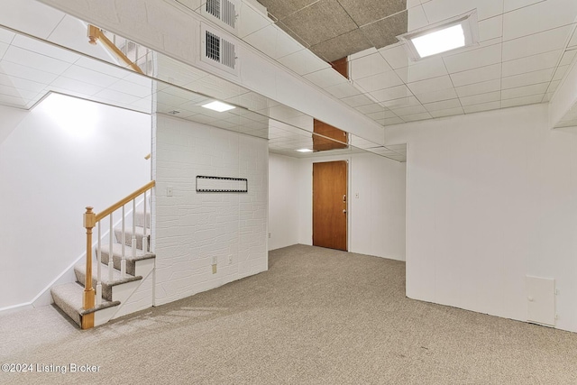 basement featuring carpet floors and a drop ceiling