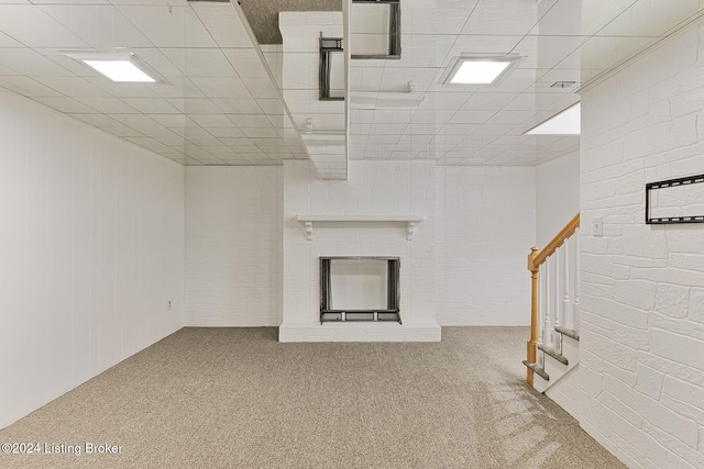 unfurnished living room with carpet and a paneled ceiling