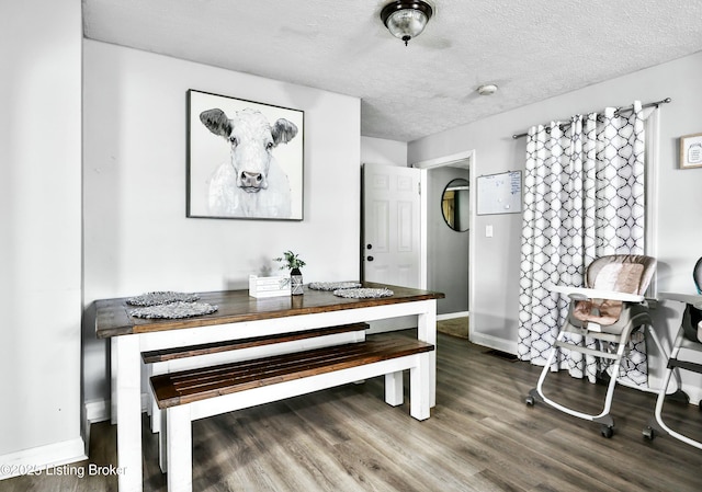 dining area featuring hardwood / wood-style flooring and a textured ceiling