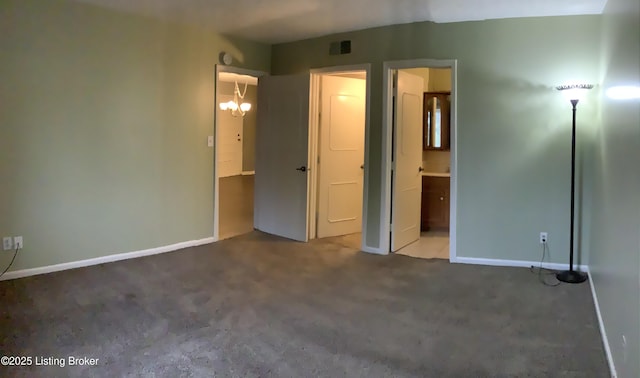 unfurnished bedroom featuring ensuite bathroom and carpet