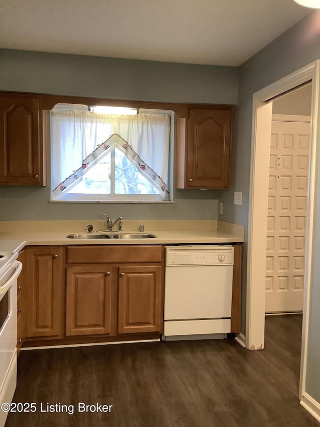 kitchen with dark wood-type flooring, white appliances, and sink