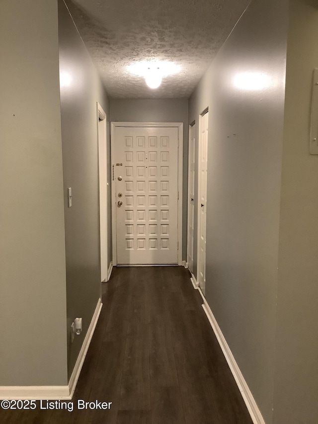 corridor featuring dark hardwood / wood-style floors and a textured ceiling