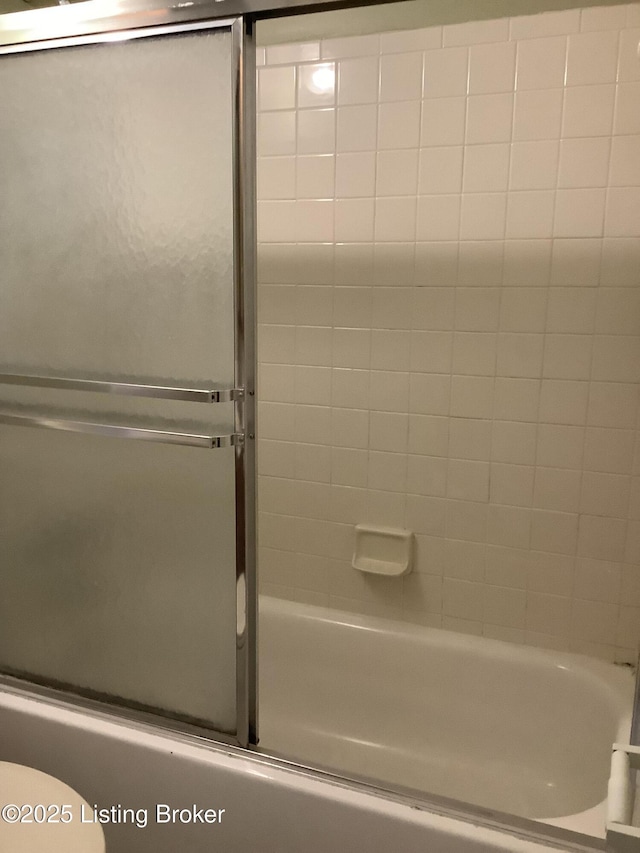 bathroom featuring shower / bath combination with glass door and toilet