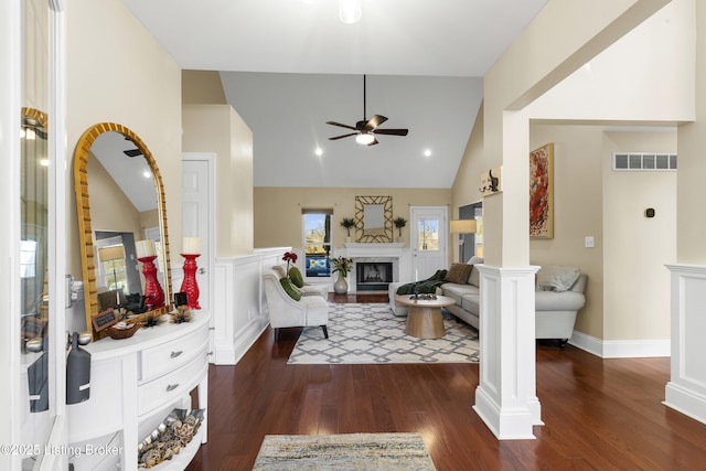 living area featuring lofted ceiling, dark wood-style floors, visible vents, and a premium fireplace